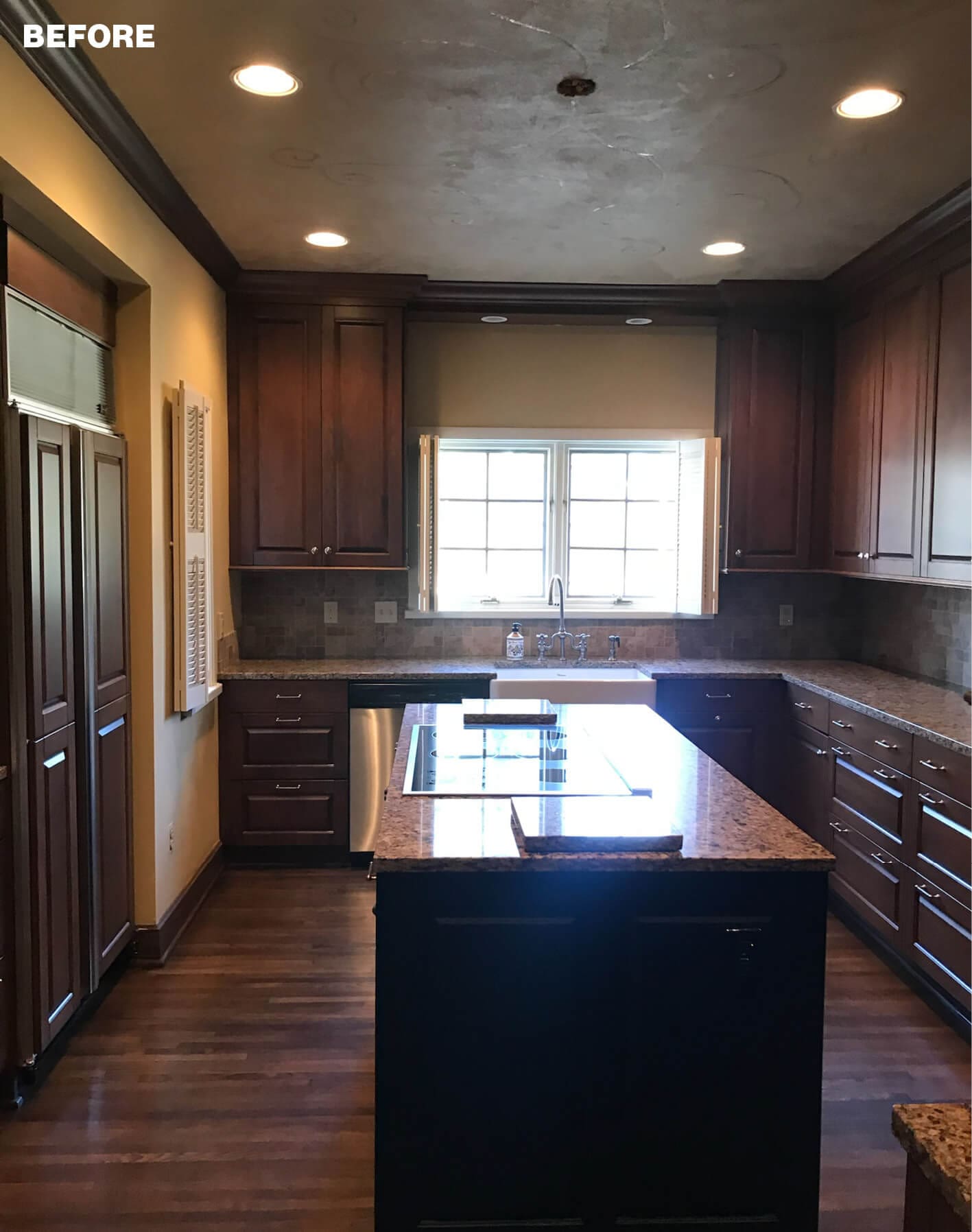 Dark wood kitchen with granite island and window