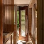 Brown brick wall, wooden slat screen, and a wooden door.