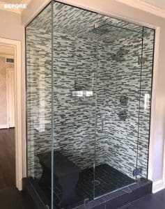 Black and gray mosaic tile shower surround with glass enclosure.