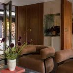 Brown leather sofa with books and a vase of flowers.