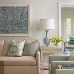 Cream sofa with blue pillows and a book, near a side table.