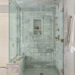 Marble shower with glass enclosure and towel bar.