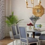 Dining room with textured wallpaper, gold chandelier, and patterned curtains.