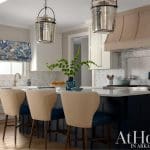 Kitchen with island, pendant lights, and blue patterned roman shade.