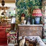 Dark green wallpaper with floral pattern, ornate furniture, and a cat.