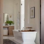 White marble bathroom with freestanding tub and vanity.