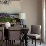 Gray upholstered dining chairs, table, and rug in a dining room.
