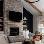 Stone fireplace with TV and built-in shelves in a living room.