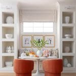 White built-in shelving with fabric shades and framed art.
