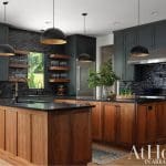 Dark kitchen with wood island, brick backsplash, and pendant lights.