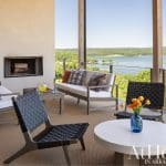 Outdoor patio with seating, fireplace, and lake view.