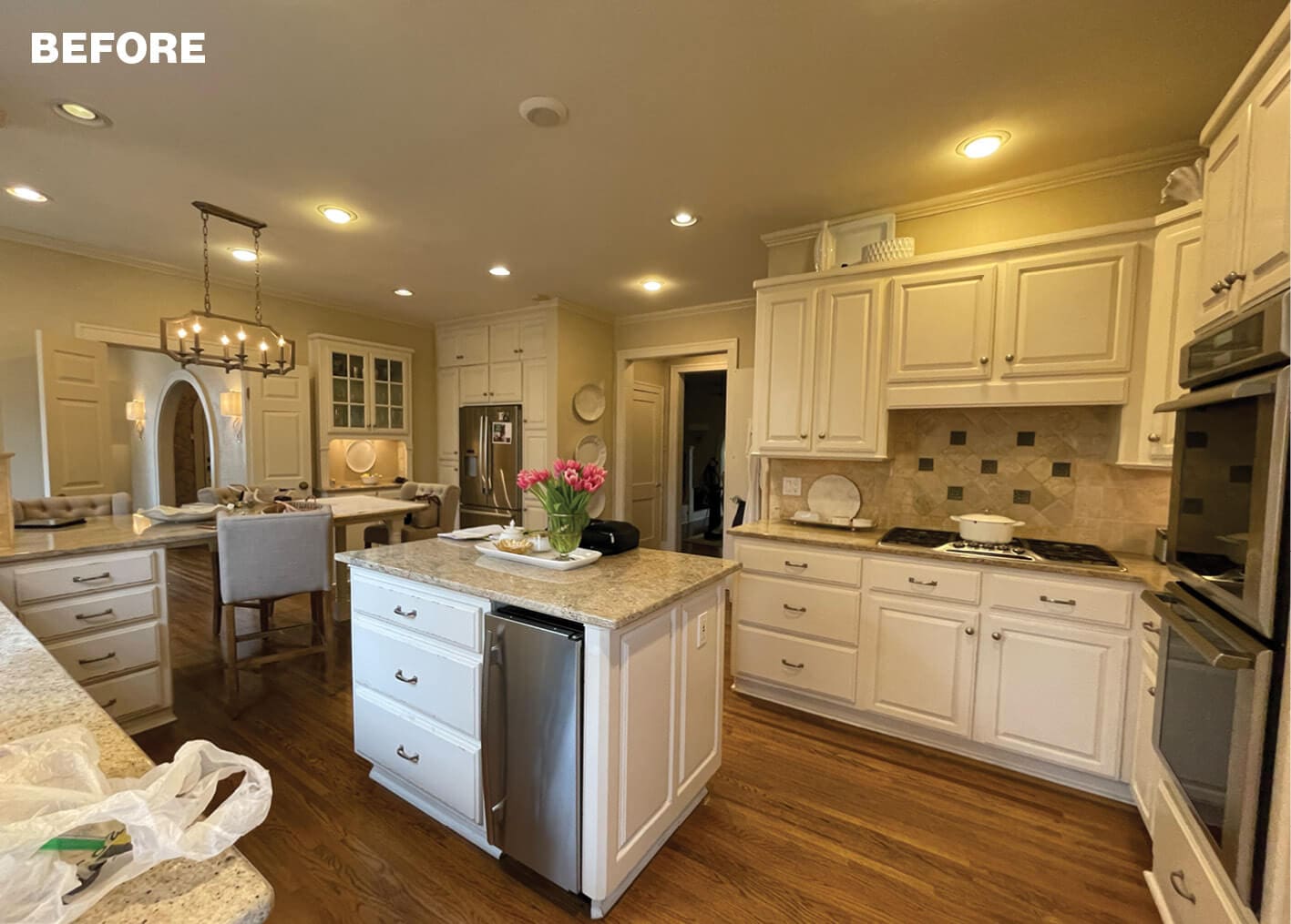 White kitchen with granite island and white cabinetry.