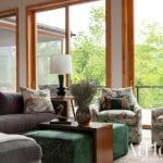 Gray sofa with patterned cushions and a coffee table in a wood-paneled room.