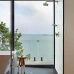 Modern bathroom with large window overlooking a lake.