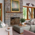 Stone fireplace with a large framed painting and wooden mantel.