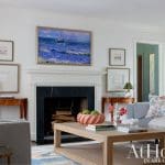 Gray sofa, coffee table, fireplace, and artwork in a living room.