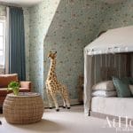 Blue and white wallpapered bedroom with giraffe and leather sofa.