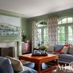 Green painted wall with arched windows and floral curtains.