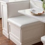 White built-in bench with marble top and nailhead trim.