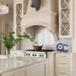 Cream-colored kitchen cabinet with a bronze bull head and glass-paneled display.