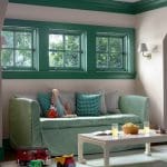 Green window trim, light green sofa, and toy collection.