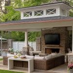 Stone patio with outdoor television and seating area.