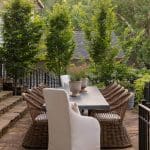 Outdoor dining area with stone steps, chairs, and a table.