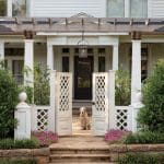 White farmhouse with a covered porch and trellis.
