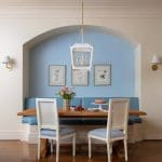 Blue wall niche with a wooden dining table and chairs.