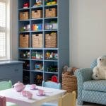 Blue built-in shelving unit with woven baskets and toys.