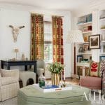 Living room with patterned curtains, bull skull, desk, and built-in bookshelves
