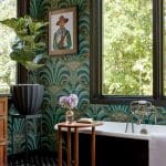 Bathroom with green art deco wallpaper, black clawfoot tub, and brass fixtures.