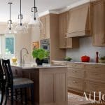 Light wood kitchen island with seating and appliances.