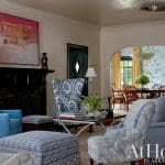 Living room with blue patterned chairs, black fireplace, and dining room beyond