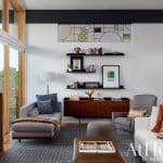 Living room with gray chaise, armchair, white sofa, and wood sideboard.