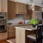 Kitchen with wood cabinetry, island, and pendant lighting.