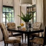 Dining room with dark wood table, patterned chairs, and cream curtains.