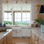 Kitchen with white cabinets, marble countertops, wood floors, and large window overlooking a