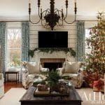 Living room with fireplace, Christmas tree, and floral armchairs