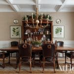 Dining room with dark wood table, leather chairs, hutch, and botanical prints.