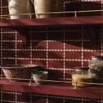 Burgundy kitchen shelves with scalloped tile backsplash, ceramic jars, and decorative bowls