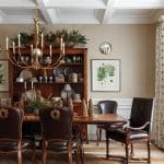 Dining room with dark wood furniture, leather chairs, and a gold chandelier.