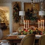 Dining table set for autumn with centerpiece of gourds, pinecones, and fruit. Christmas tree