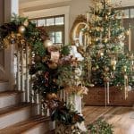 Christmas tree and garland with gold ornaments and lights on staircase