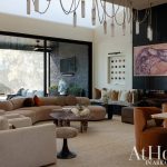 Living room with curved sofa, textured rug, marble coffee table, and abstract bird art.