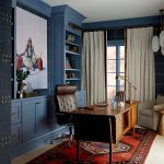 Office with blue built-in cabinets, leather chair, wooden desk, and Persian rug