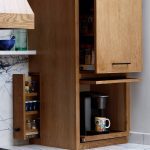 Kitchen with light oak cabinetry, marble countertops, and a pull-out spice rack.