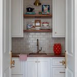 Butler's pantry with white cabinets, wood countertop, and gray subway tile backsplash.