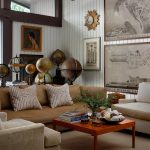 Living room with brown sectional sofa, beige armchairs, and a wooden coffee table with globes and