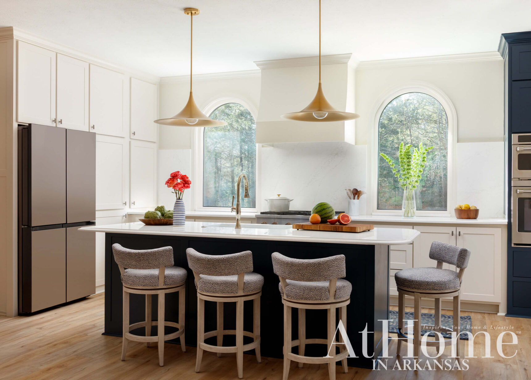 Kitchen with white cabinets, dark island, and four patterned bar stools.